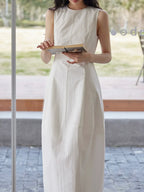 Sleeveless Maxi Dress Paired with a Woven Straw Handbag